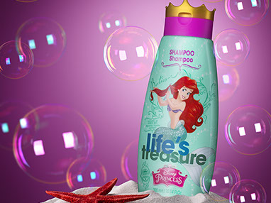 Bottiglia di shampoo per le bambine posizionata nella sabbia. Stella marina rossa sulla sinistra. Bolle di sapone intorno. Sfondo rosa scuro.