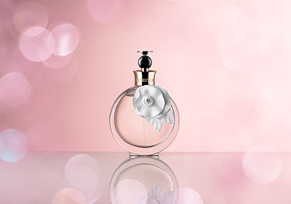Al centro una bottiglia di acqua floreale Valentina, sfondo rosa e un effetto bokeh intorno. Delicato e femminile.