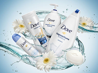 Una composizione dinamica dei vari cosmetici della linea Dove sullo sfondo azzurro, con i spruzzi d'acqua e fiori bianchi. Orizzontale.