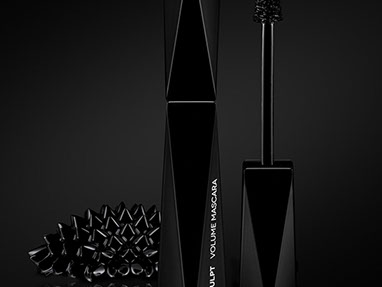 Black Mascara by Kiko with geometric shape. On the left, the shape of a black and shiny curly made of ferrofluid. Black background. Vertical.