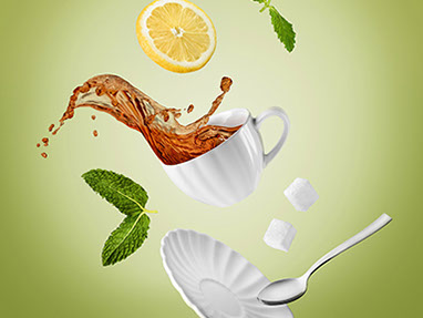 A dynamic composition with a white cup with tea, thrown into the air. Flying liquid and all elements around. Green background.