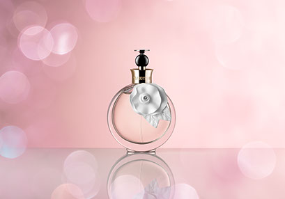 At the center a bottle of acqua floreale Valentina, pink background and a bokeh effect around. Delicate and feminine.